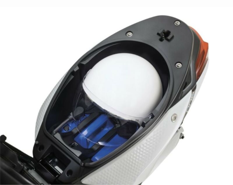 Piaggio One coffre sous la selle ouvert avec casque et batterie amovible à l'intérieur